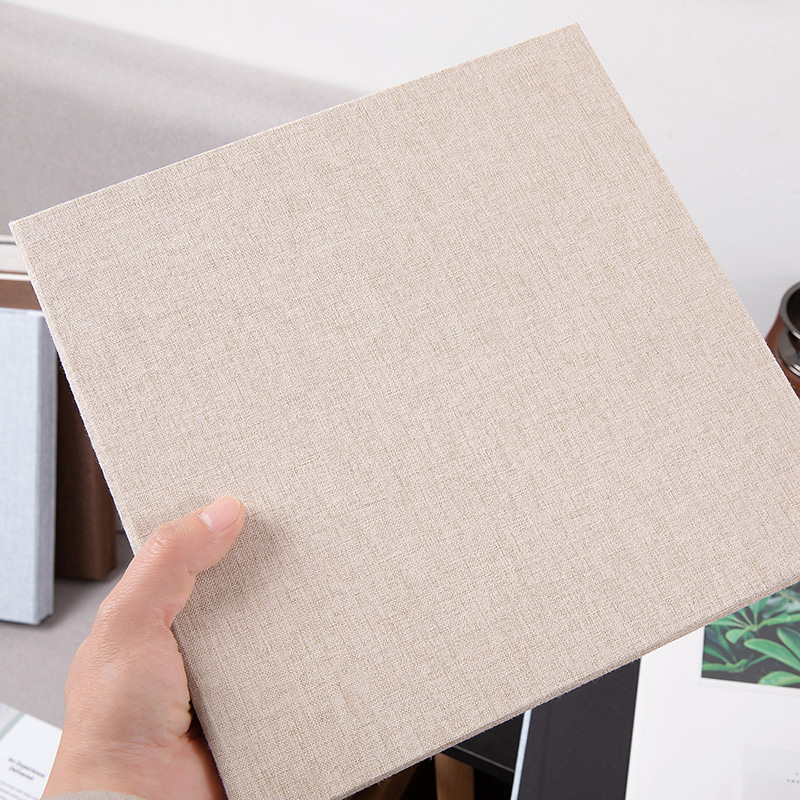 A hand holding a MYKEEPO linen album showing the woven texture